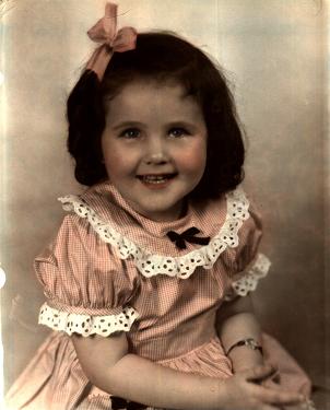A young child in a pink dress

Description automatically generated