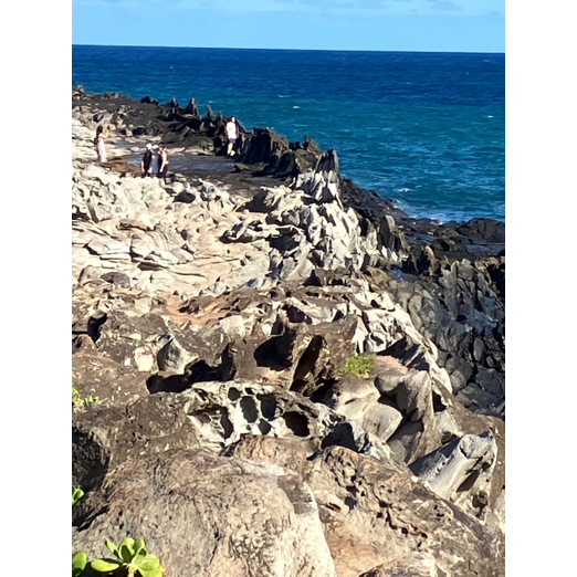 A rocky cliff with water in the background

AI-generated content may be incorrect.